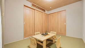 Una stanza con un tavolo in legno, sedie e un soffitto decorato con pannelli di legno.