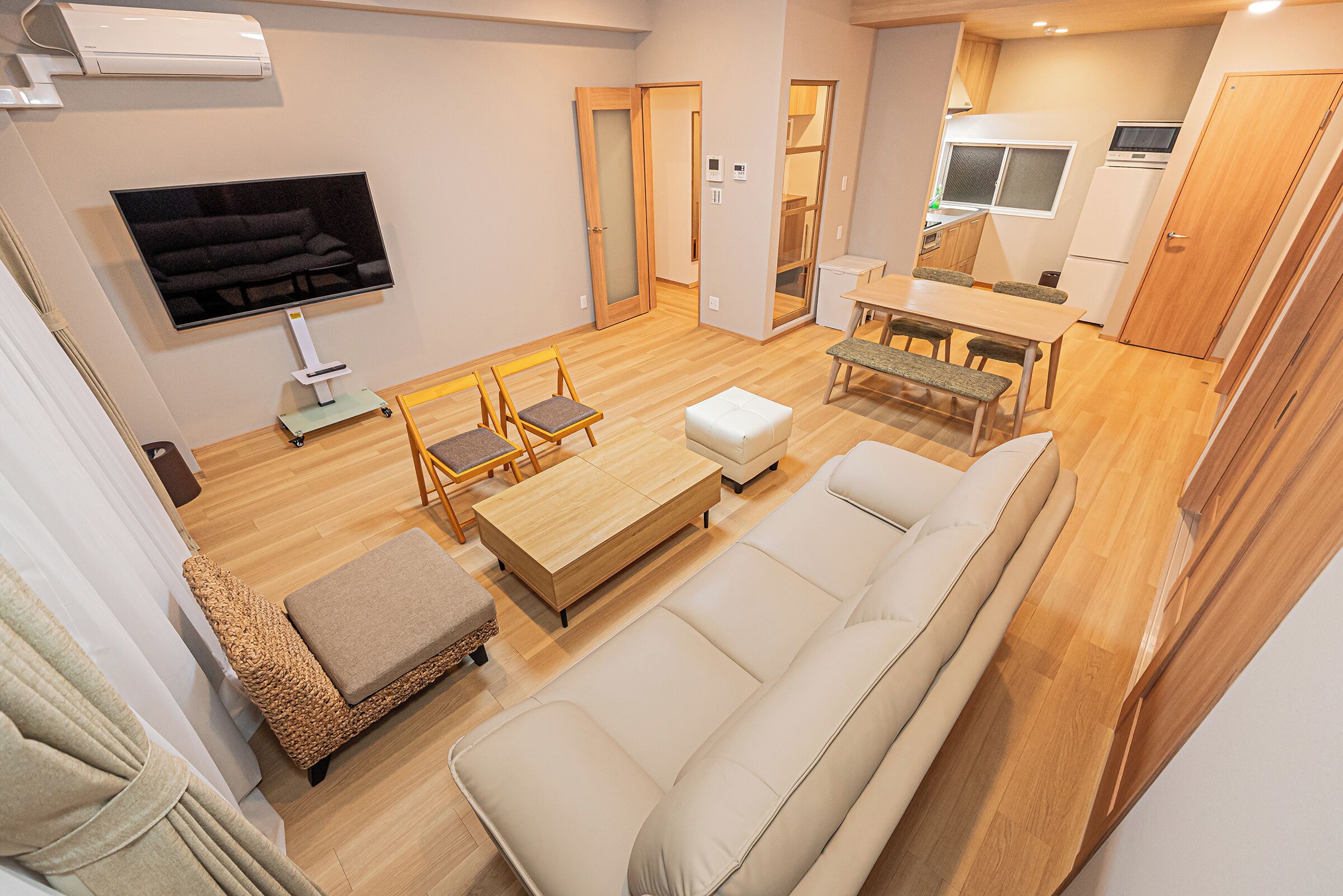 A modern living room with a sofa, a coffee table, and a TV mounted on the wall.