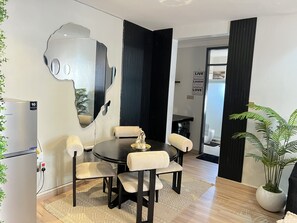 Ein moderner Essbereich mit einem runden Tisch, sechs Stühlen und einem außergewöhnlichen Wandbild.