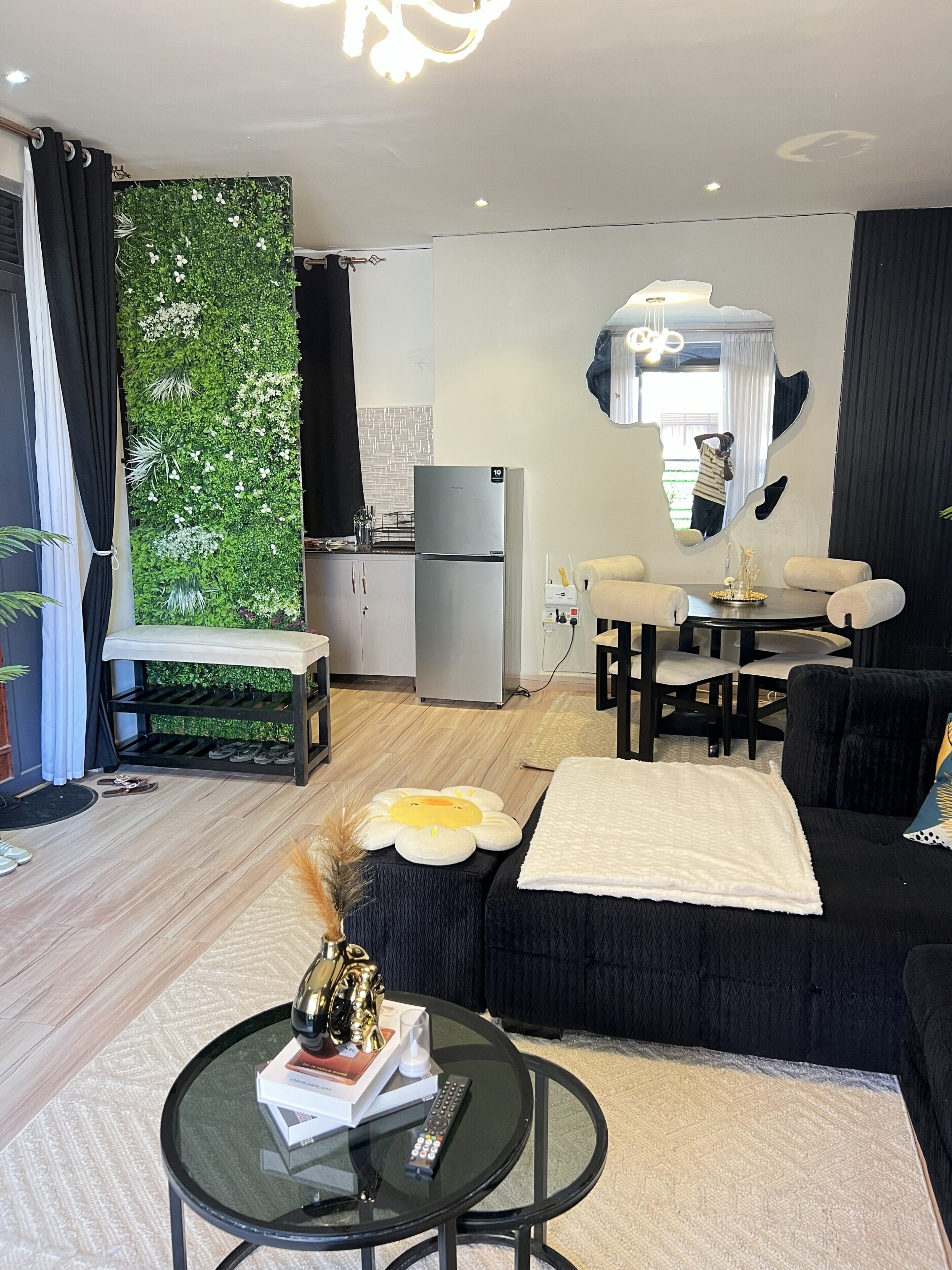 A modern living room with a sofa, a coffee table, and a dining area with a table and chairs.