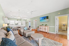 A spacious living room with a sofa set, a coffee table, and a dining area with a kitchen in the background. - Magnolia North 4834-304 (Myrtle Beach)