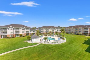 A multi-story residential building with a swimming pool and lounge chairs. - Magnolia North 4834-304 (Myrtle Beach)