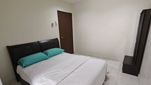 Un dormitorio con cama, una puerta y una ventana pequeña.