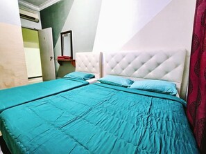 Ein Schlafzimmer mit zwei Betten, jeweils mit einer gesteppten Kopfteil, und einem roten Vorhang auf der rechten Seite.