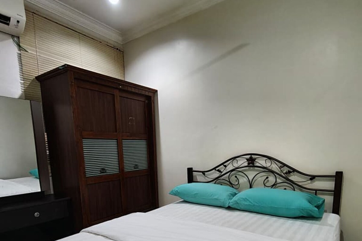 Ein Schlafzimmer mit Bett, Kleiderschrank und Deckenventilator.