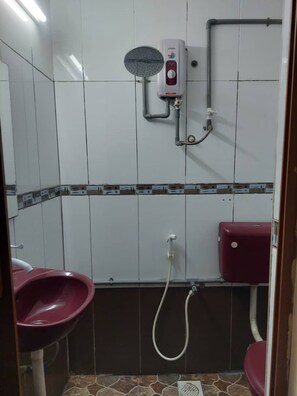 Ein Badezimmer mit Dusche, Toilette und Waschbecken.