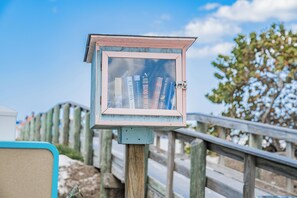 A weathered bookcase with books, mounted on a wooden post. - Coconut Cottage | Beach Retreat Steps to Sand, Mini Golf & More (Indian Shores)