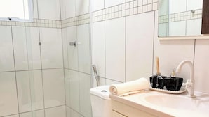 A bathroom with white tiles, a sink with a faucet, a towel, and two bird-shaped soap dispensers. - ASA Verona Park 06 2 Bedrooms Single Story House Timbo (Timbo)