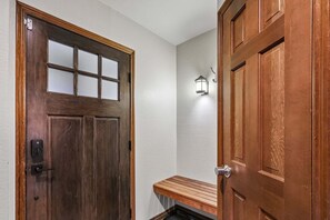 A wooden door with a glass panel and a keypad lock, a bench, and a wall-mounted light fixture. - Ski-In/Ski-Out* | 2 Blocks to Main Street | Private Sauna (Park City)