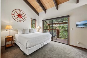 Une chambre avec un grand lit, une boussole fixée au mur, une télévision et un balcon avec vue.