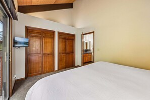 A bedroom with a large bed, wooden wardrobes, a television, and a mirror. - Ski-In/Ski-Out* | 2 Blocks to Main Street | Private Sauna (Park City)