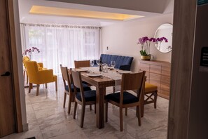 A dining area with a wooden table, chairs, and a blue sofa. - Orchids Suite: Elegance, spaciousness, and privacy—an exceptional stay (Ciudad de México)