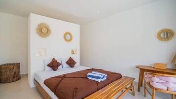 Quarto com cama, mesa de cabeceira e uma cadeira.