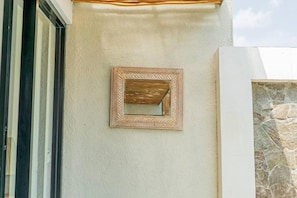 Una pared con textura y un espejo en marco.