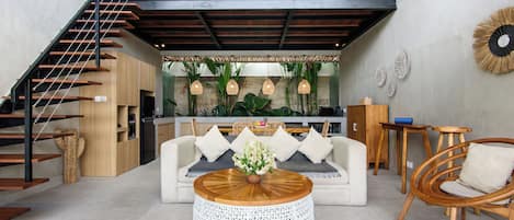 A modern interior with a staircase, a sofa, a coffee table, and a dining area.