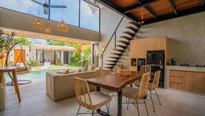 Una cucina moderna con tavolo e sedie di legno, forno integrato e isola centrale.