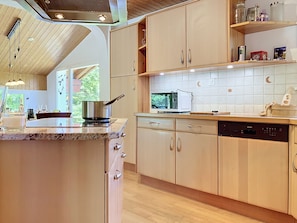 Cocina con gabinetes de madera, microondas y lavavajillas.