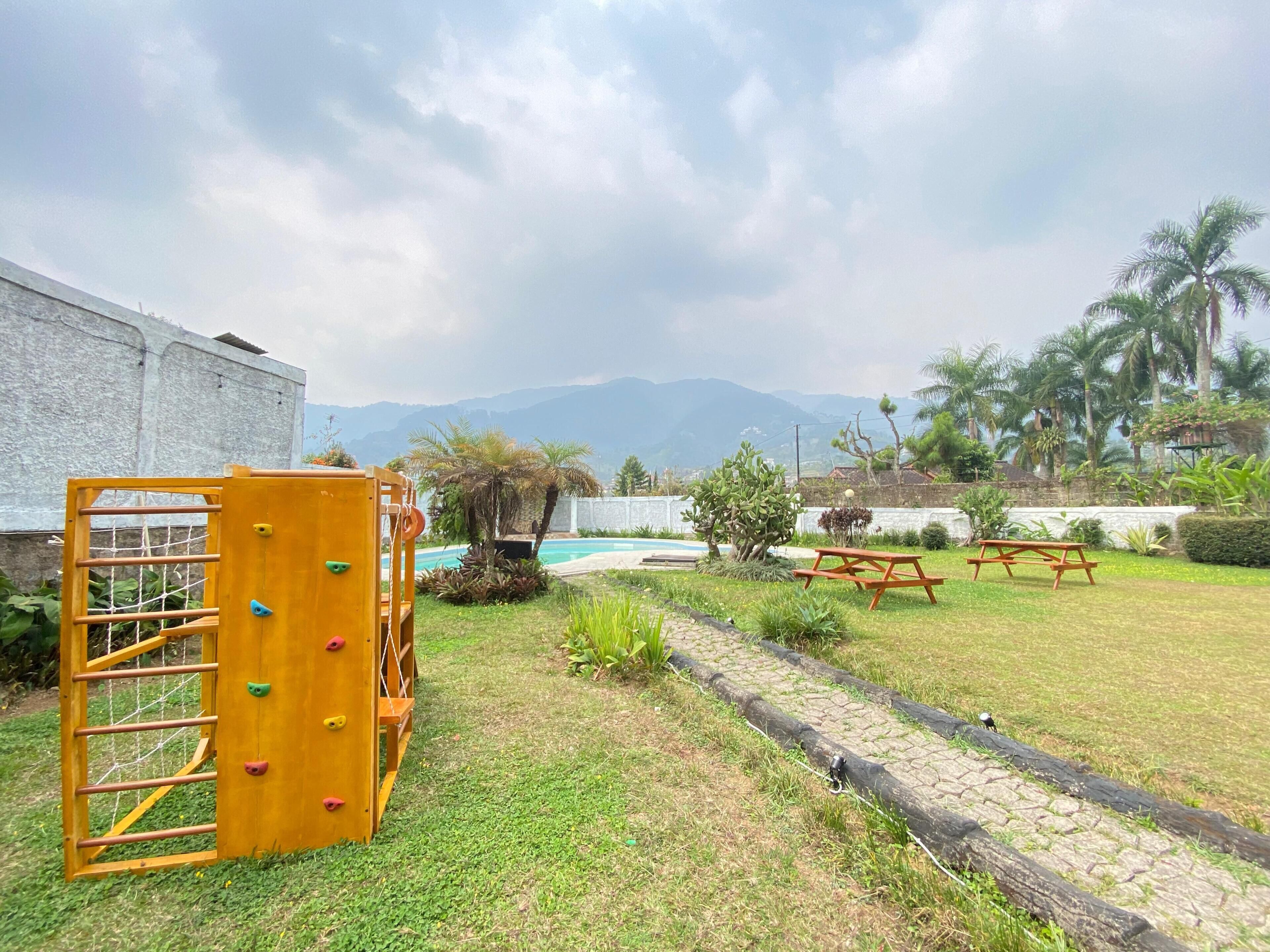 A playground with climbing structures, a picnic table, and a swimming pool.