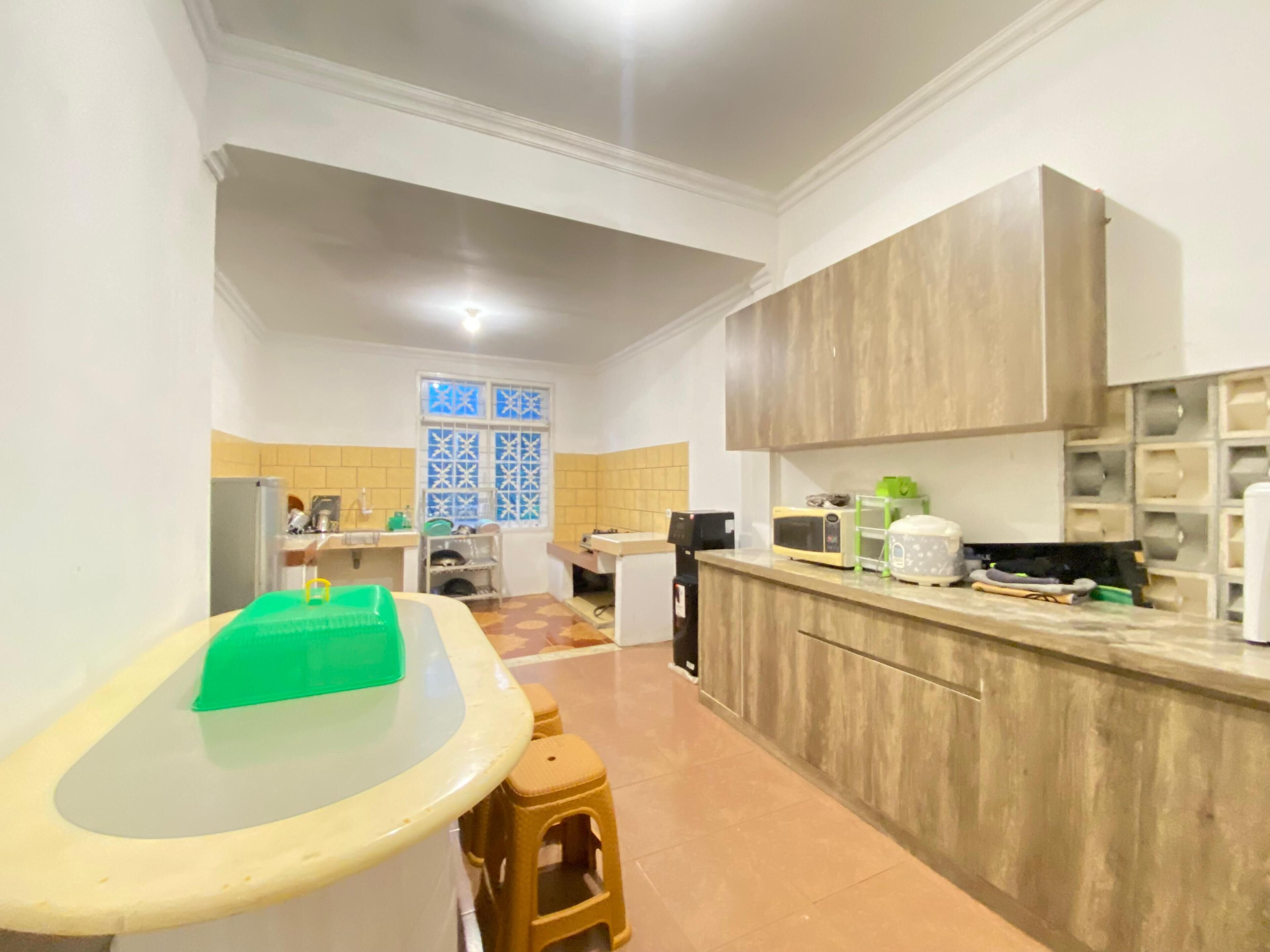 A kitchen with a built-in microwave, a coffee machine, and a green storage box on the counter.