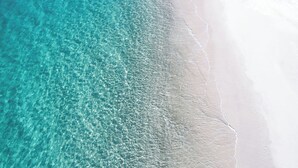 A beach with clear turquoise water and white sand.