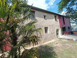 A building with a stone facade, a red roof, and a small window. - Spacious house with a spa and movie theater—for families, groups, or events (Longaulnay)