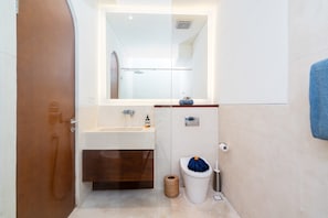 A bathroom with a sink, mirror, toilet, and a towel rack. - Villa Casa Libra (Pererenan)
