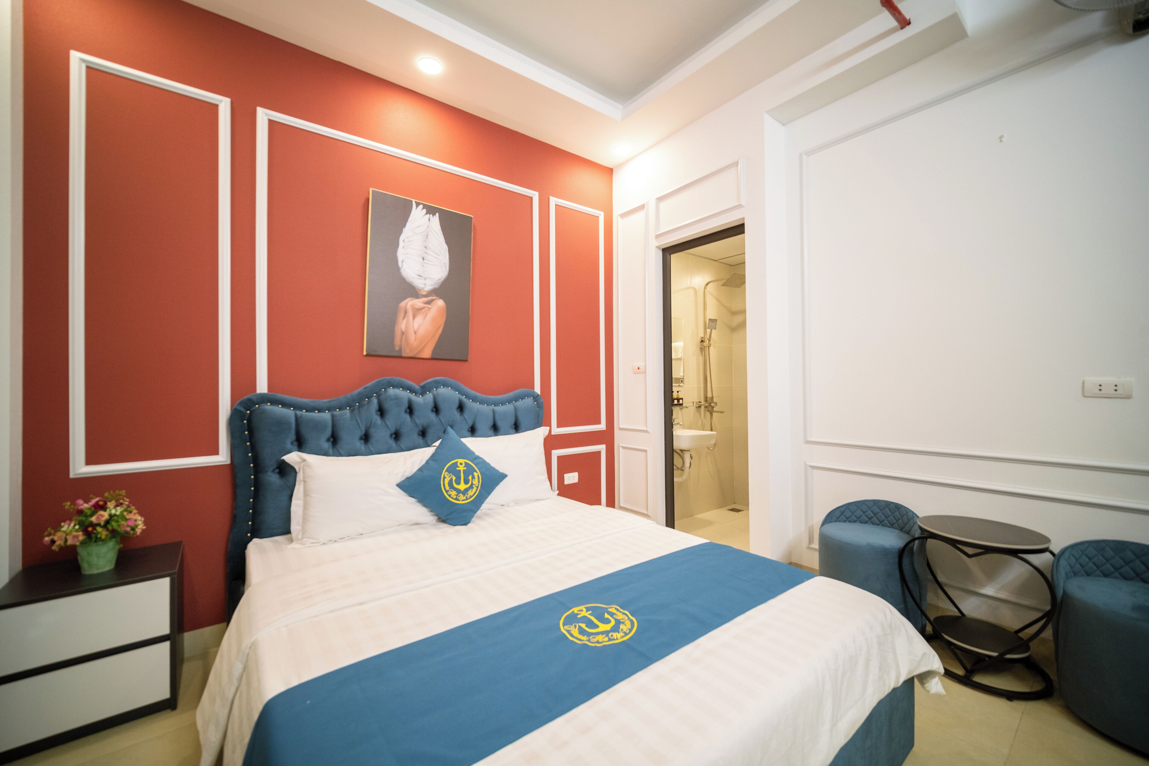 Un dormitorio con una cama grande, una mesita de noche, una silla y un cuadro en la pared.