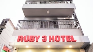 De buitenkant van Hotel Ruby 3, met een opvallend bord en een modern ontwerp.