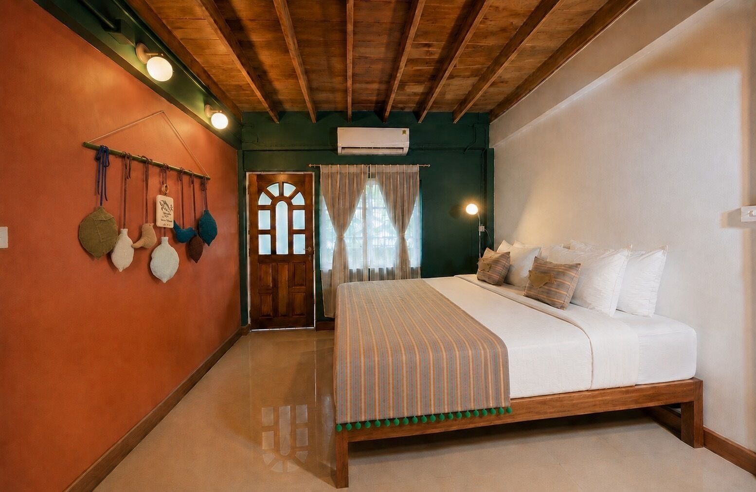 A bedroom with a wooden bed frame, a large window with curtains, and a wall-mounted air conditioning unit.