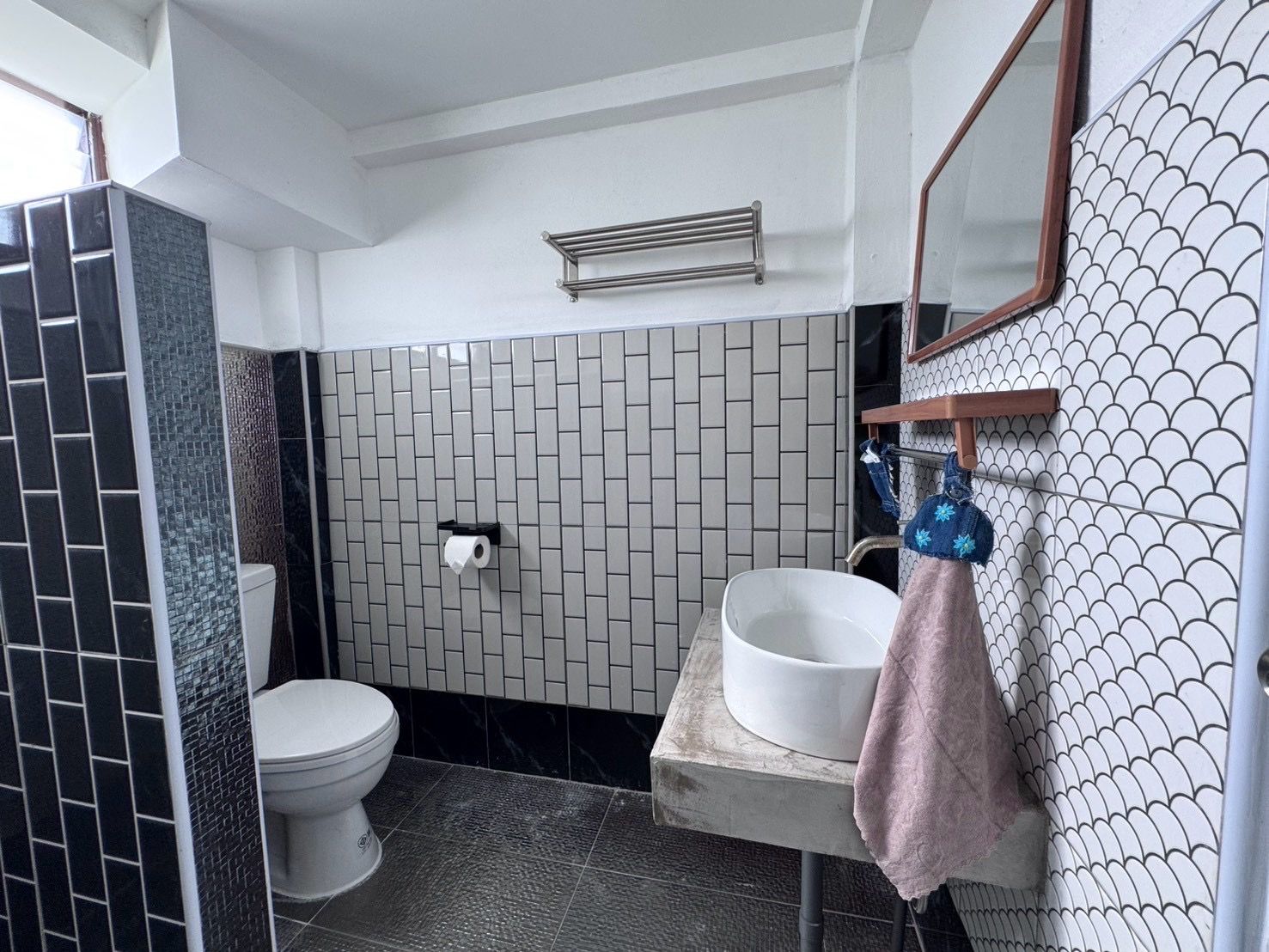 Un baño con inodoro, lavamanos y espejo.