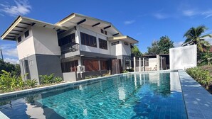 Une maison moderne à deux étages avec une piscine.