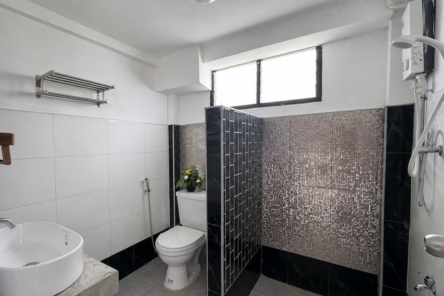 Un baño con lavamanos blanco, inodoro y zona de ducha.