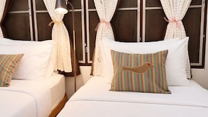 A hotel room with two beds, white bedding, striped pillows, and curtains tied with ribbons. - Retro at Mae Rim (Mae Rim)