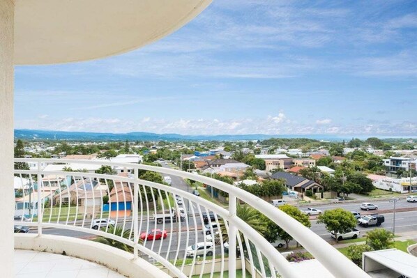 Un balcone con vista su una zona residenziale, che comprende case e una strada.