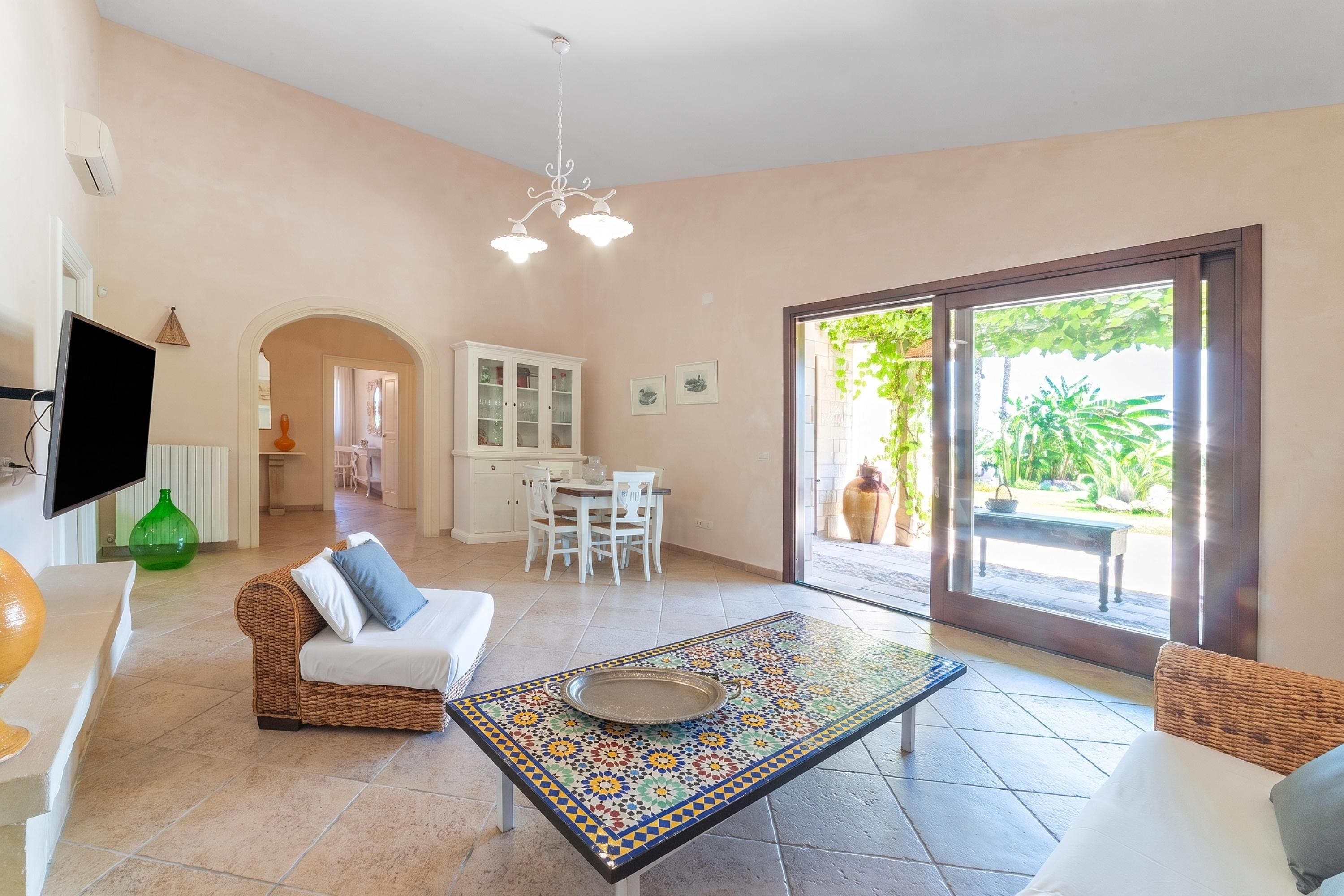 A spacious living area with a dining table, a sofa, and a television.