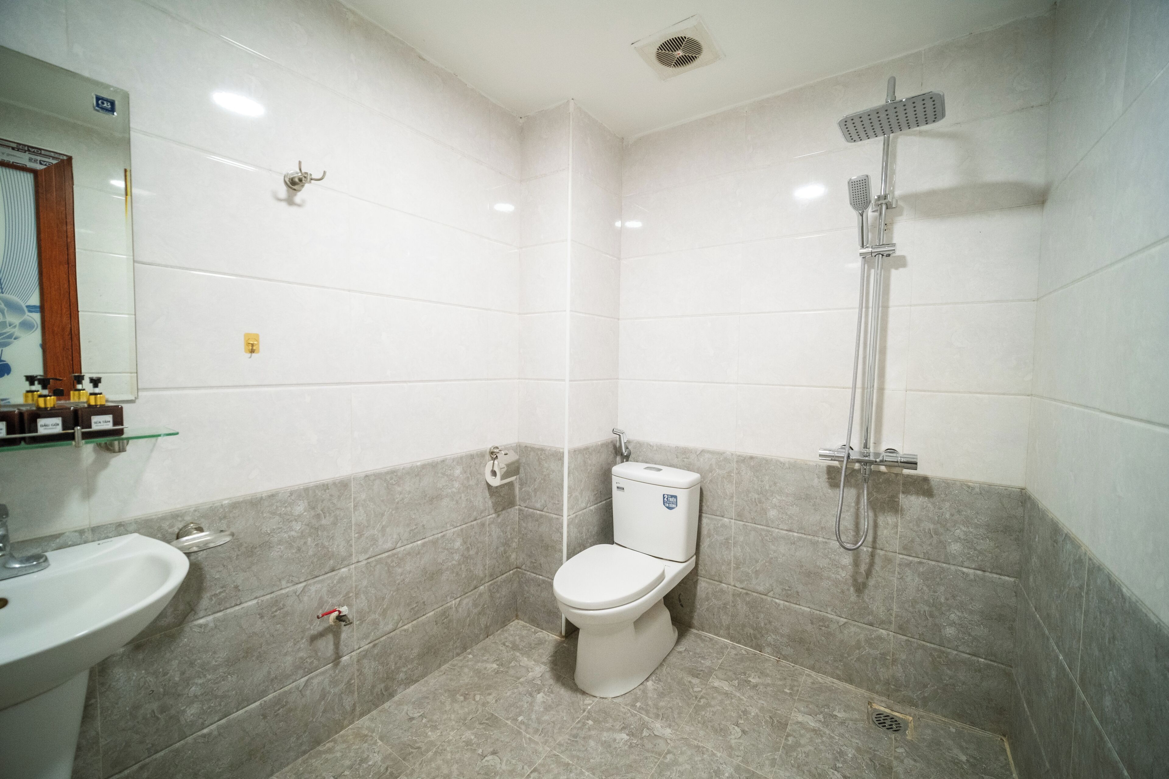 Une salle de bain avec des toilettes, un lavabo et une douche.