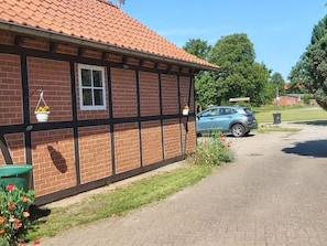 A brick building with a tiled roof, a car parked in front, and a clear sky. - De lüt Ferienhof Jameln Lüneburger-Heide/Wendland by Interhome (Jameln)