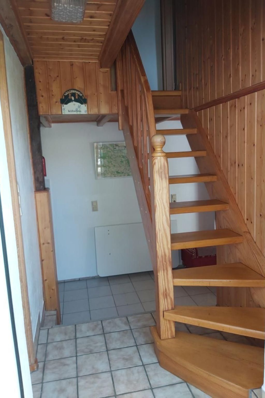 Eine Holztreppe mit Handlauf, die zu einer Zwischenebene führt.