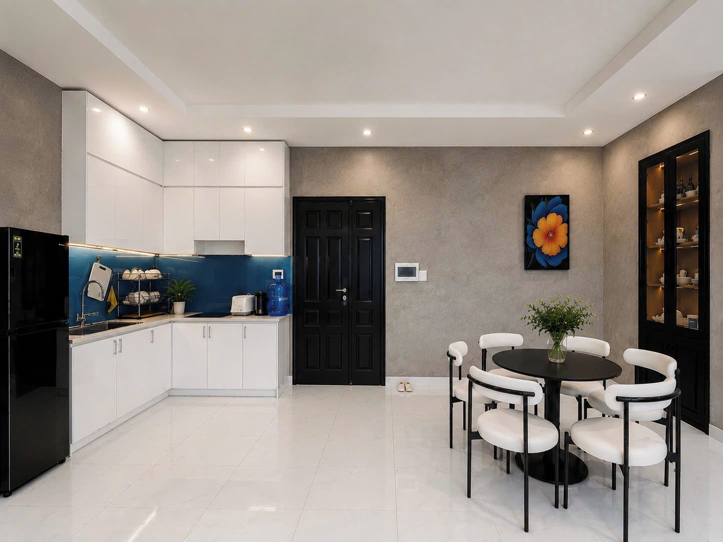A modern kitchen with white cabinets, a black refrigerator, and a blue backsplash.