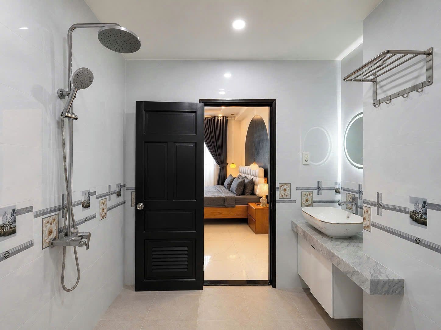Een moderne badkamer met een douche, wastafel en spiegel.