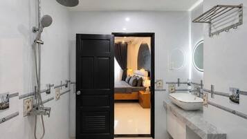 Een moderne badkamer met een douche, wastafel en spiegel.