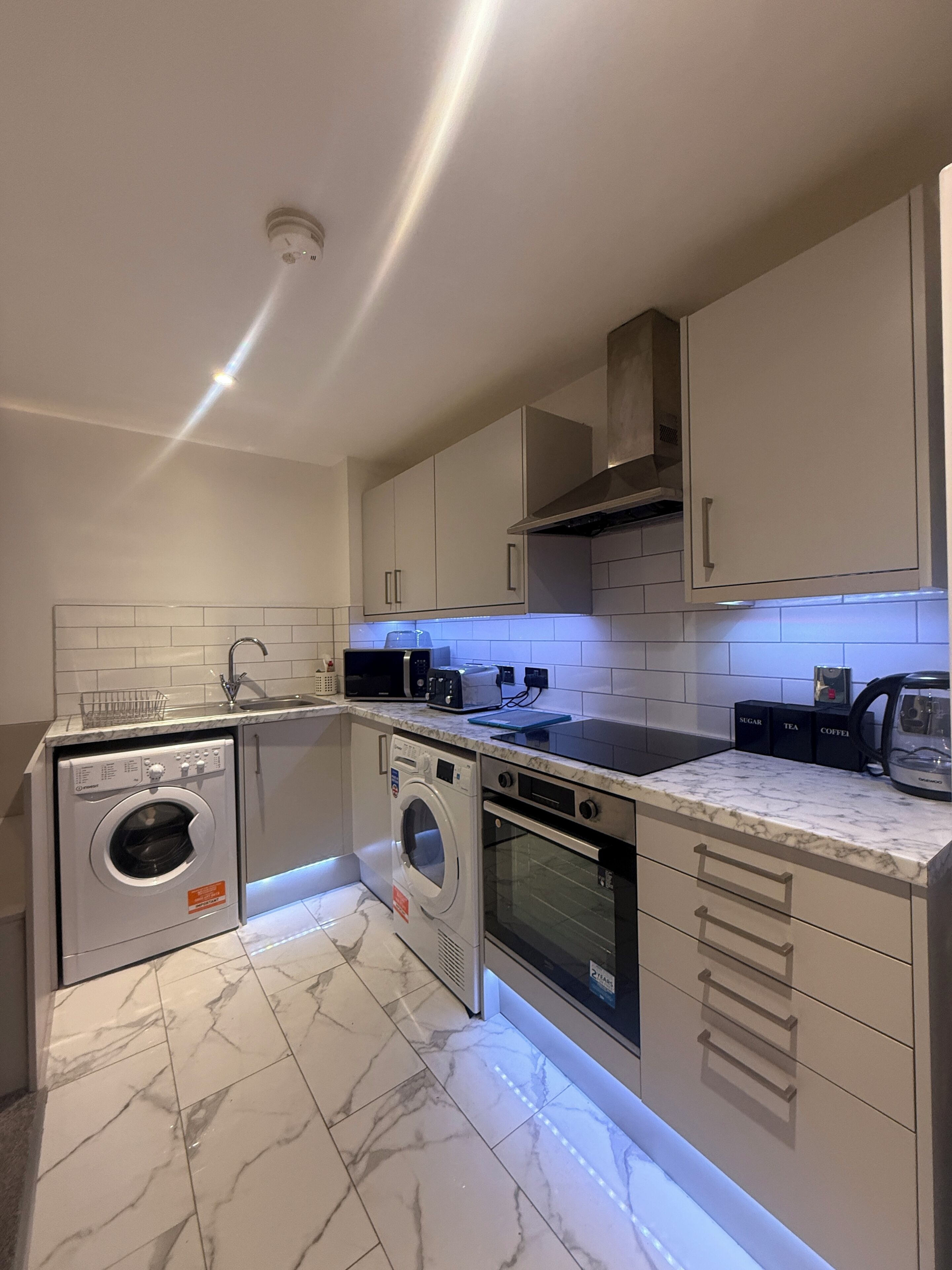 A modern kitchen with a built-in washer, oven, and microwave.