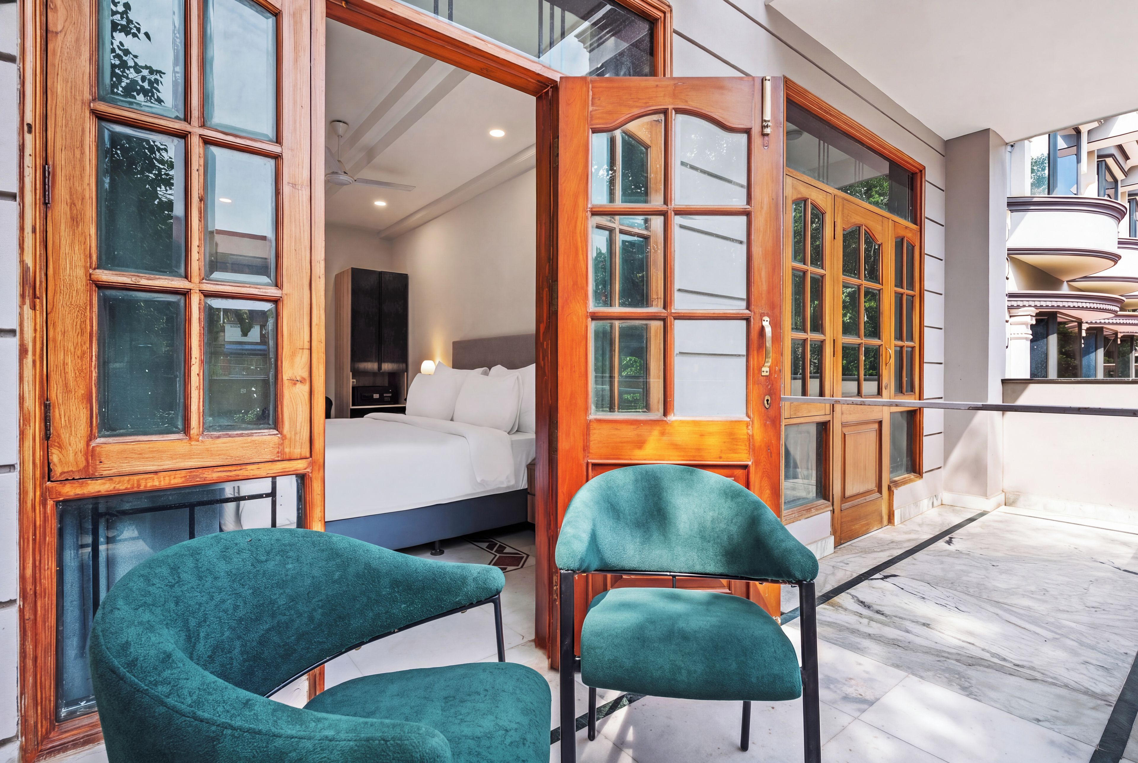 A hotel room with a bed, a desk, and a large window.