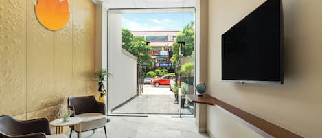 Un vestíbulo de hotel con televisor, zona de estar y vistas a la calle.
