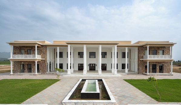 A large, multi-story building with a central courtyard and a water feature.