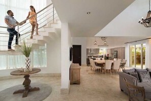 Ein modernes Interieur mit Treppe, Essbereich und Wohnbereich.