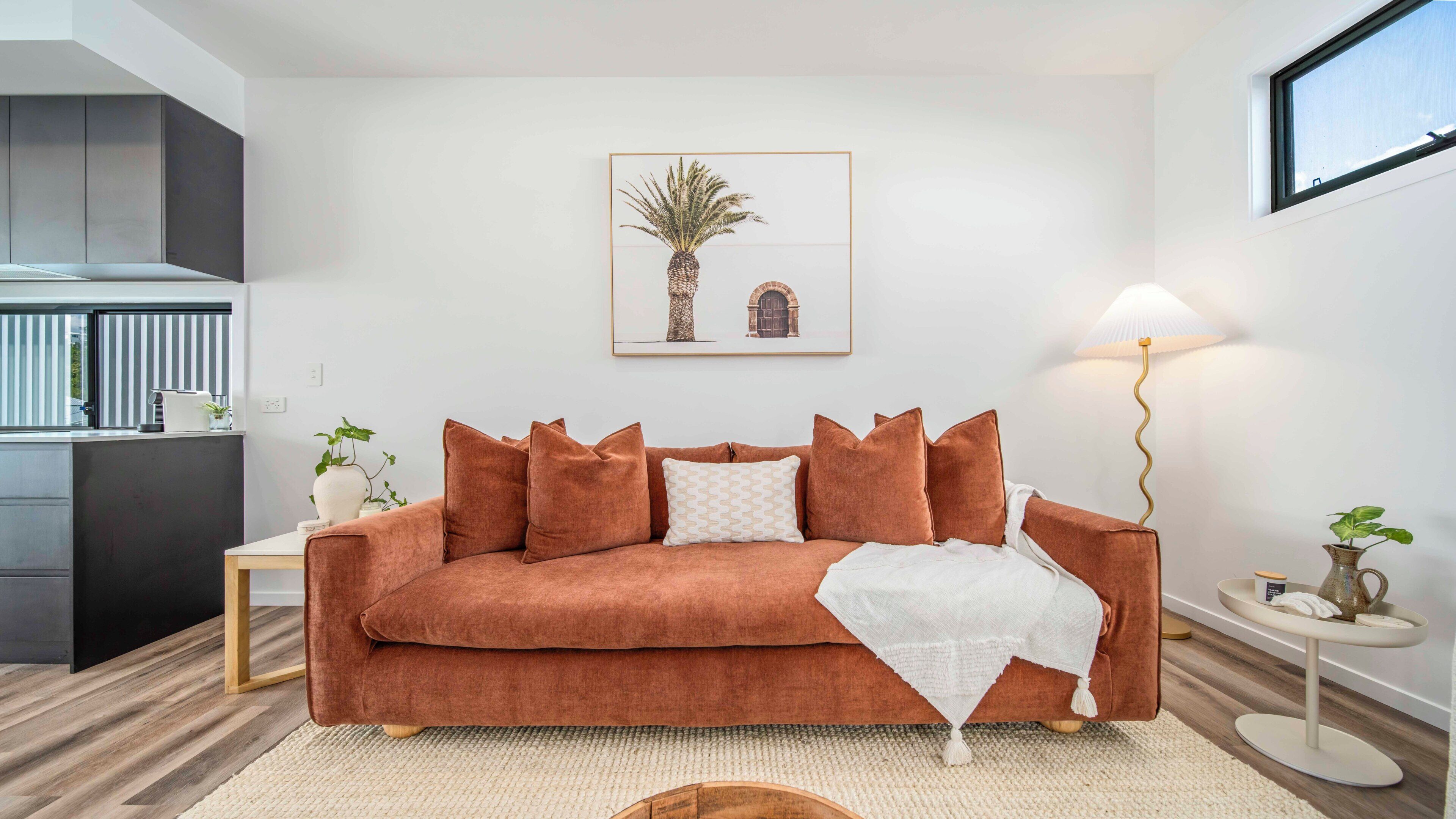 Un salon avec un canapé, une table basse, une lampe et un tableau encadré au mur.