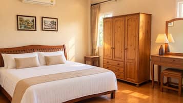 Habitación de hotel con cama, armario de madera y escritorio con lámpara.