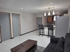 Una sala moderna con un sofá, una mesa de centro y un comedor con dos sillas.