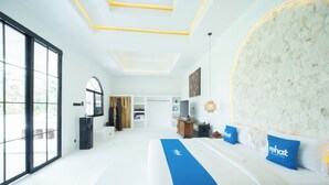 A hotel room with a large bed, a desk, a wardrobe, and a view of the outdoors. - Rehat at D'Sawah Villas (Rancakalong)